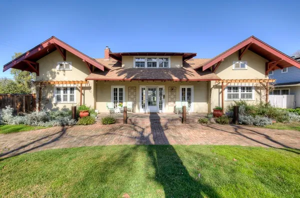 a front view of a house with a yard and potted plants