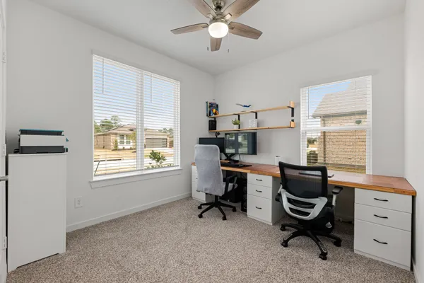 a view of a workspace with furniture and a window