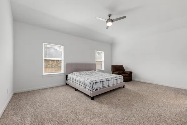 a spacious bedroom with a bed and a window