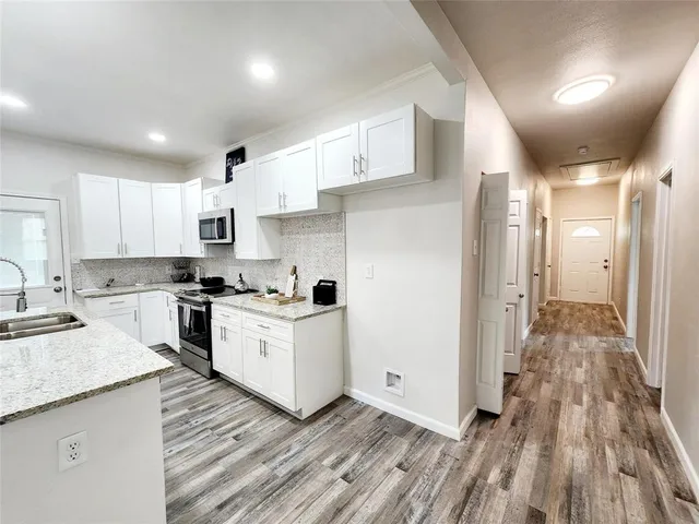 a kitchen with cabinets and wooden floor