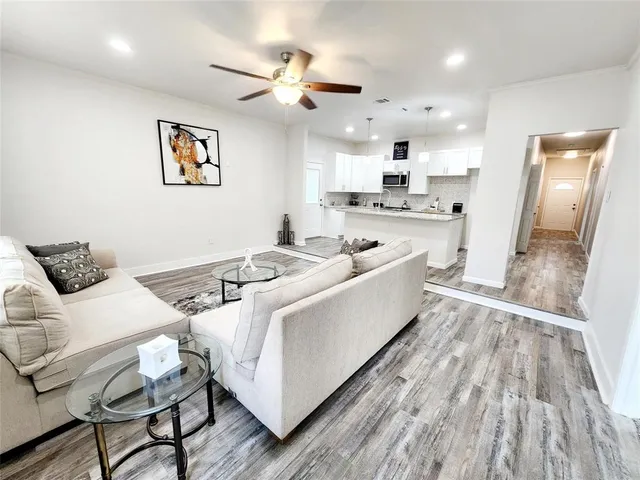 a living room with furniture and a wooden floor