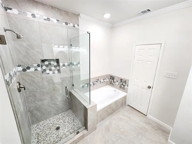 a bathroom with a tub sink shower and mirror
