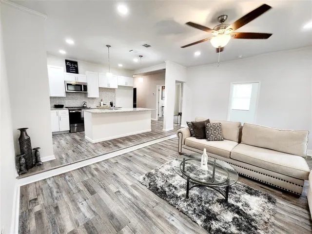 a living room with furniture and a wooden floor