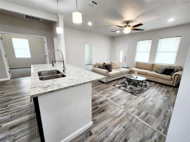 a living room with granite countertop furniture a window and wooden floor