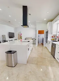 a kitchen with stainless steel appliances a sink a stove a microwave a refrigerator a counter top space and cabinets
