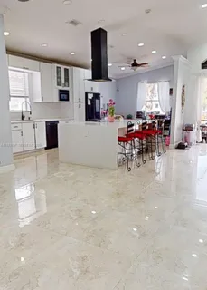 a kitchen with stainless steel appliances a sink a stove a microwave a refrigerator a counter top space and cabinets