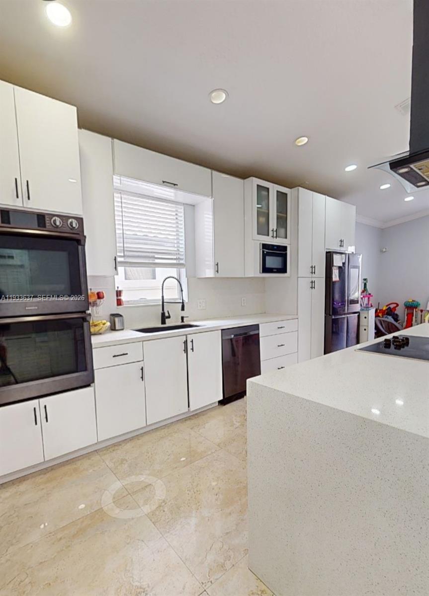 13877 Southwest 50th Street Miramar, FL 33027 - Photo 14 of 25 a kitchen with stainless steel appliances a microwave a sink and a stove