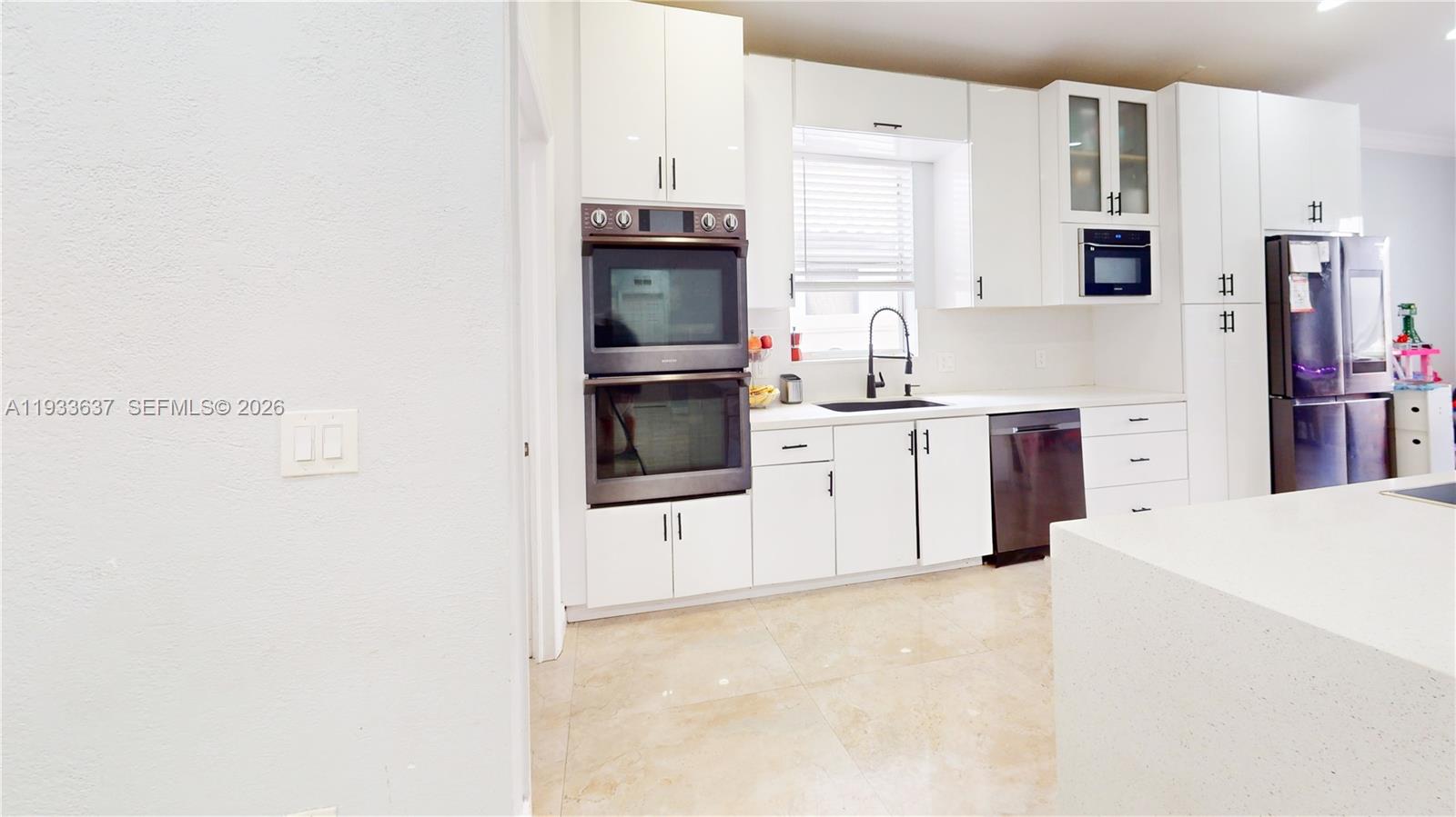 13877 Southwest 50th Street Miramar, FL 33027 - Photo 14 of 54 a kitchen with cabinets and white appliances