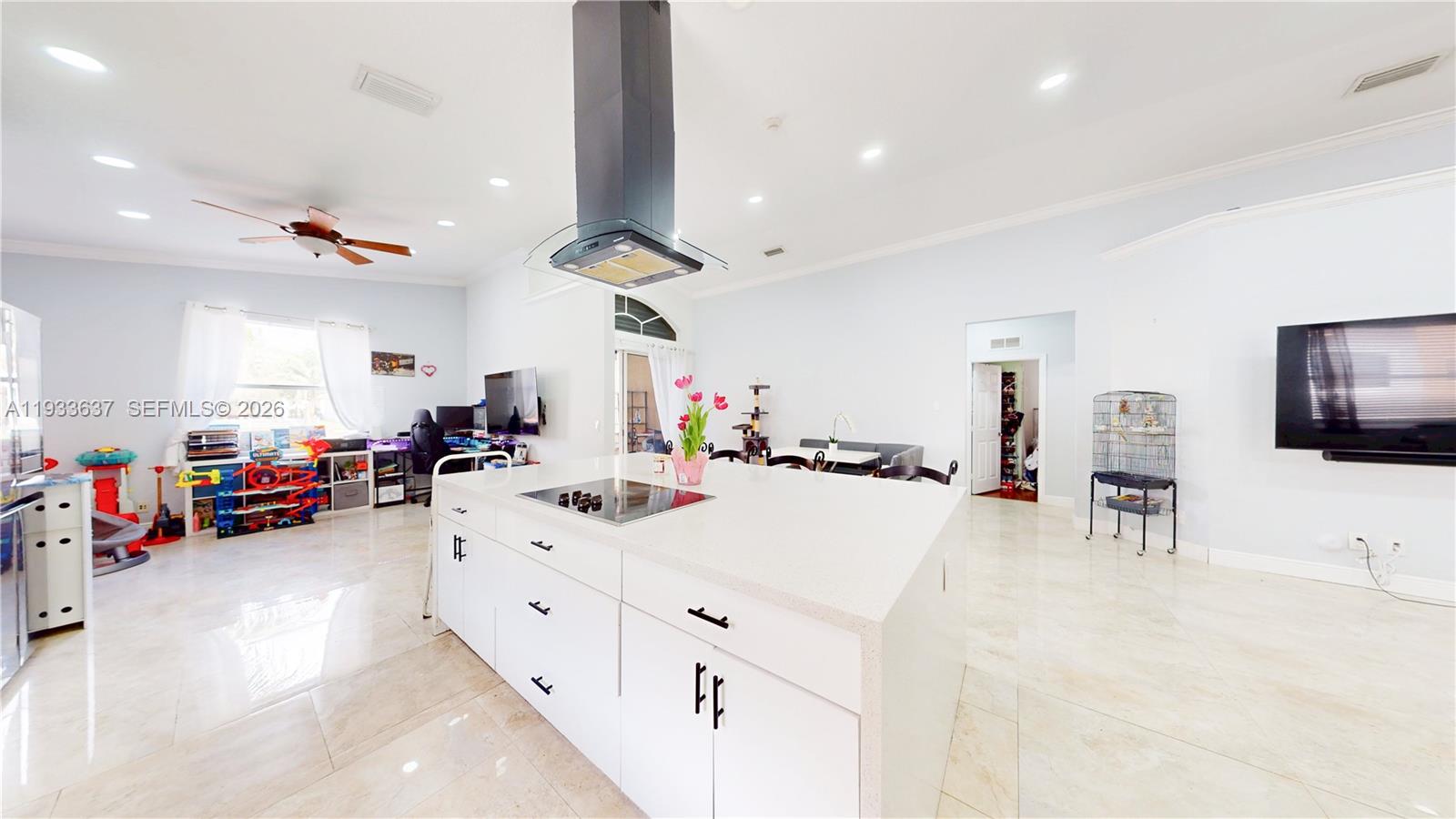 13877 Southwest 50th Street Miramar, FL 33027 - Photo 15 of 54 a large white kitchen with a large counter top a stove and a chandelier