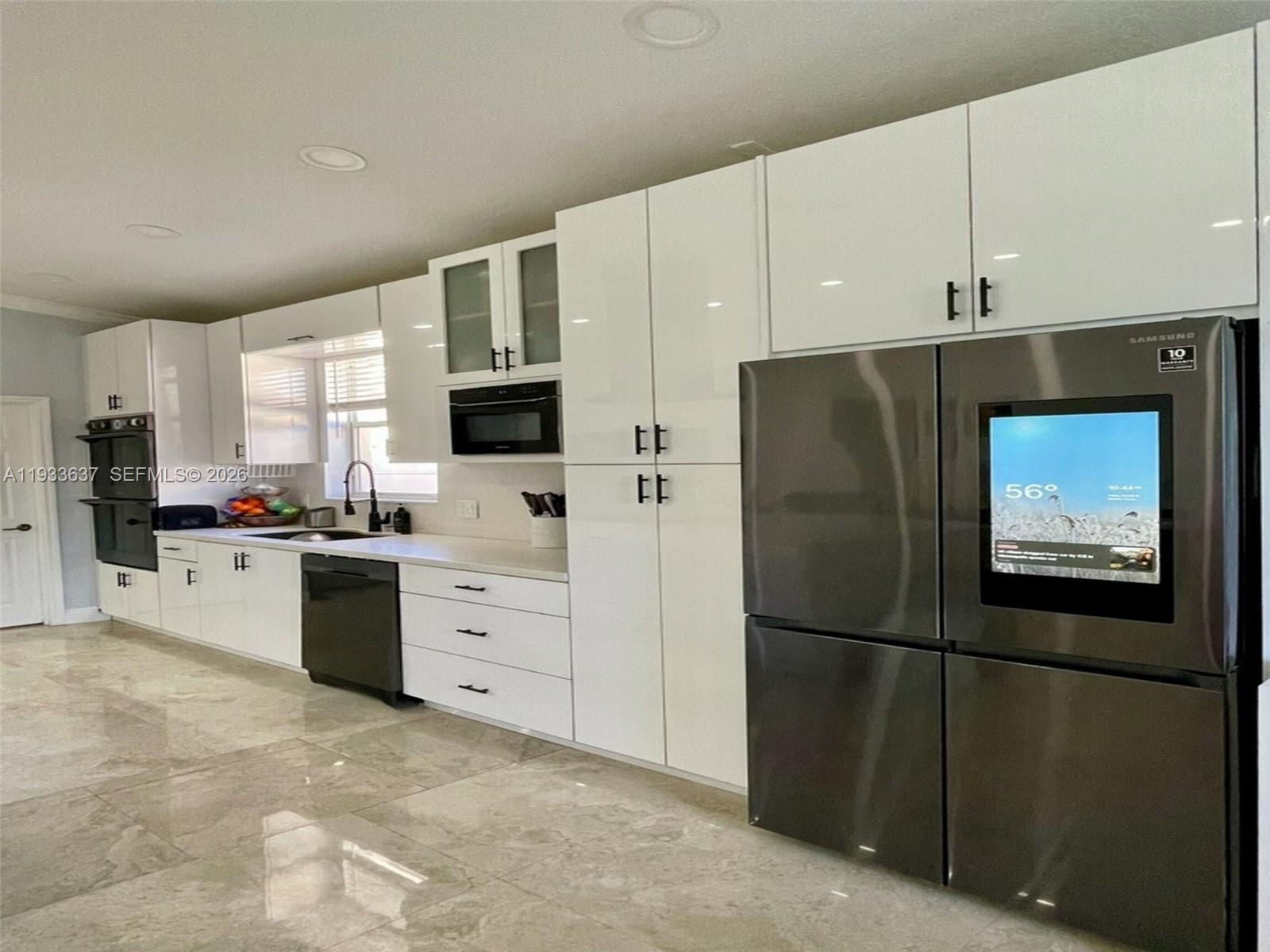 13877 Southwest 50th Street Miramar, FL 33027 - Photo 17 of 54 a kitchen with white cabinets and stainless steel appliances