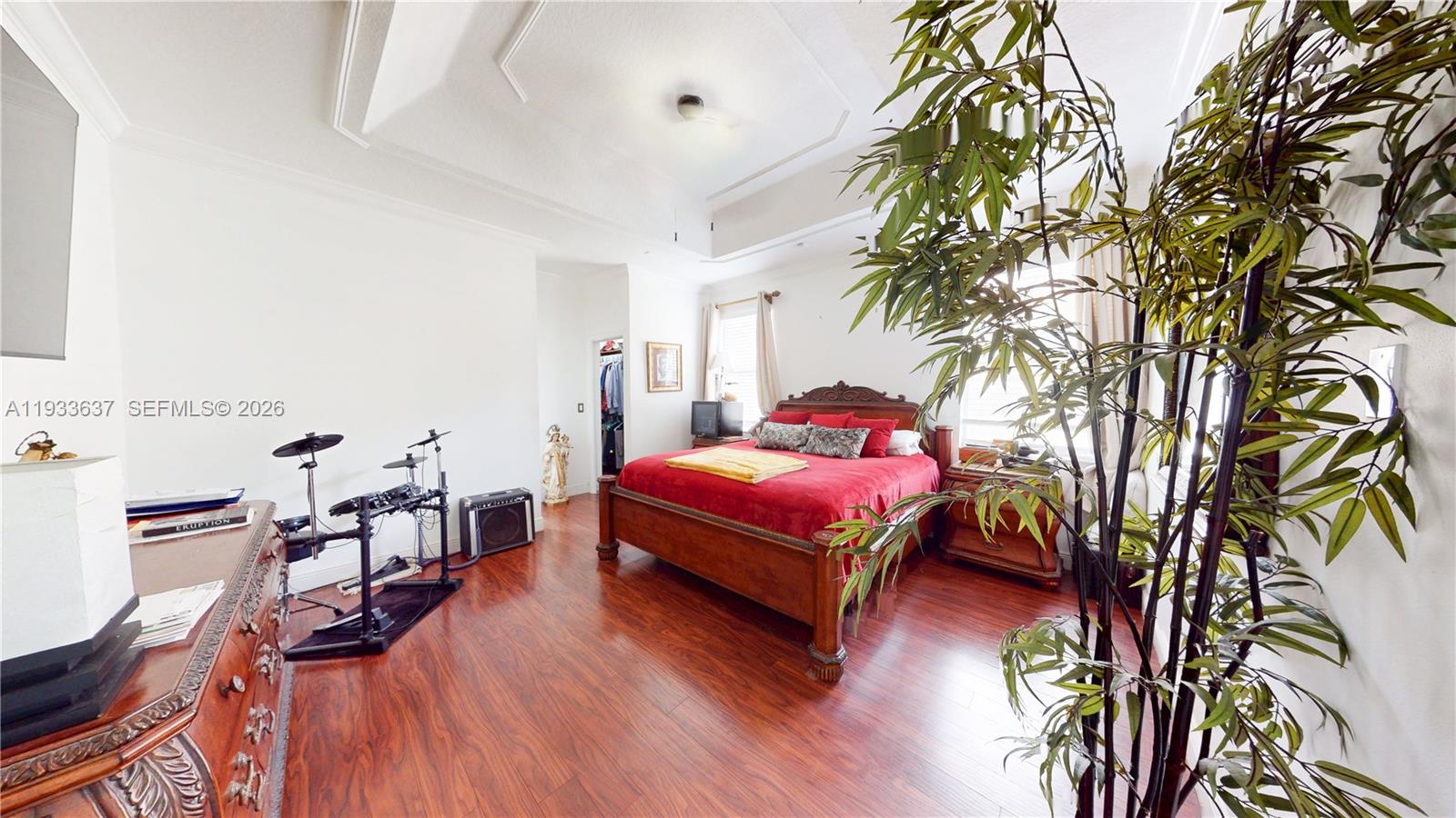 13877 Southwest 50th Street Miramar, FL 33027 - Photo 27 of 54 a spacious bedroom with a bed and a bookshelf with wooden floor