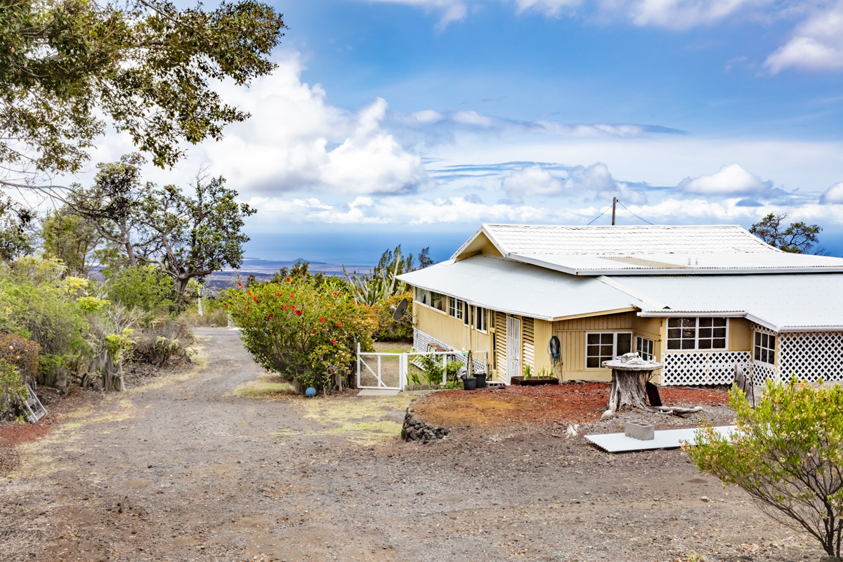 92-1663 Keaka Parkway Ocean View, HI 96704 - Photo 1 of 30 a view of a patio with table and chairs under an umbrella