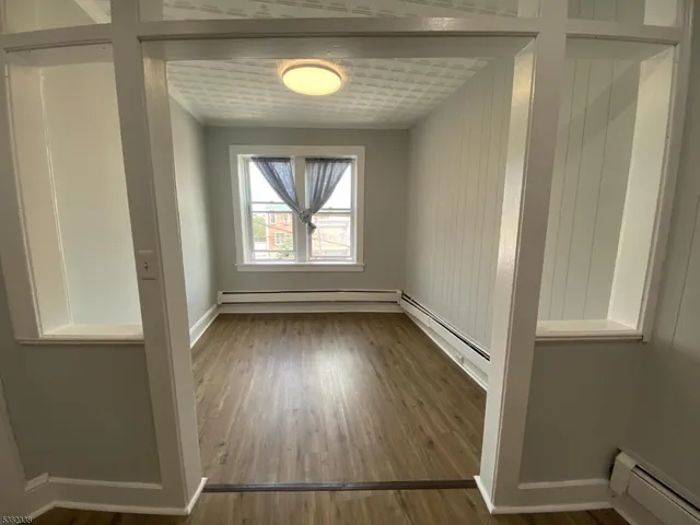 an empty room with wooden floor and closet
