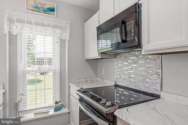 a kitchen with a stove a microwave and a window