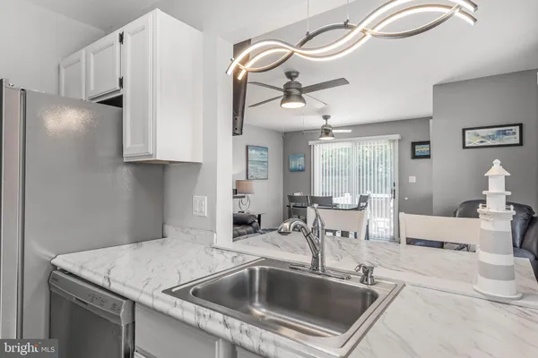a kitchen with stainless steel appliances granite countertop a sink and a refrigerator