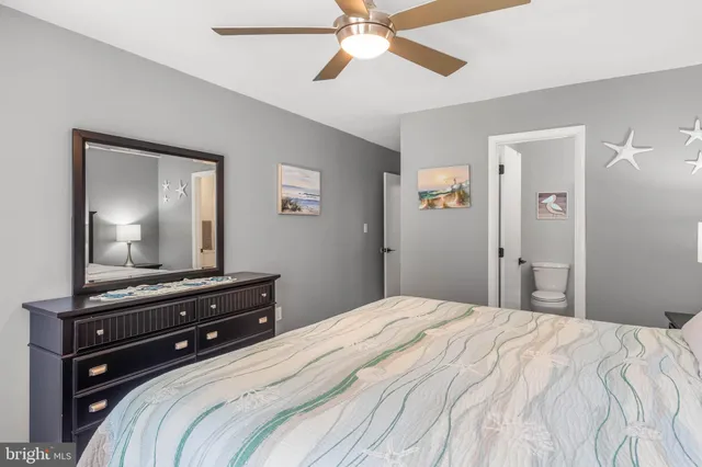 a bedroom with a bed and a mirror on a dresser