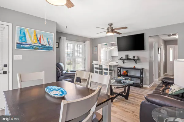 a living room with furniture kitchen view and a flat screen tv