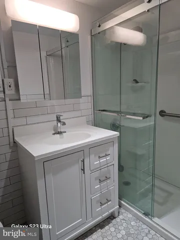 a bathroom with a shower sink and mirror