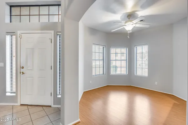 an empty room with windows and fan