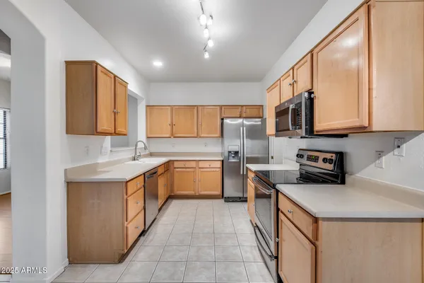 a kitchen with stainless steel appliances granite countertop a stove a sink and a refrigerator