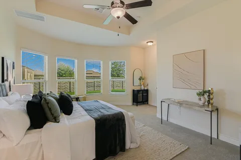 a spacious bedroom with a bed a chandelier and a large window