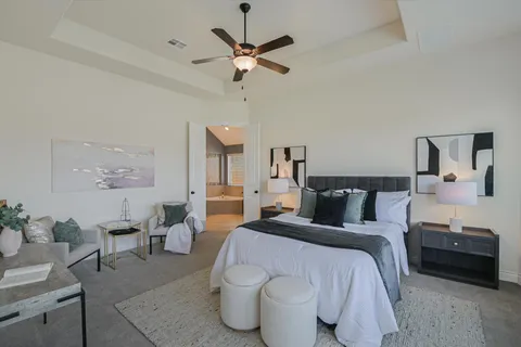 a bedroom with a bed a couch and a chandelier