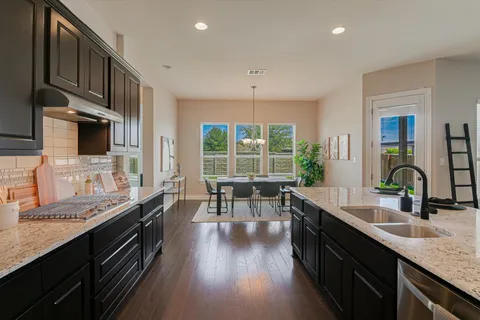 a kitchen with granite countertop a sink a counter top space appliances and cabinets