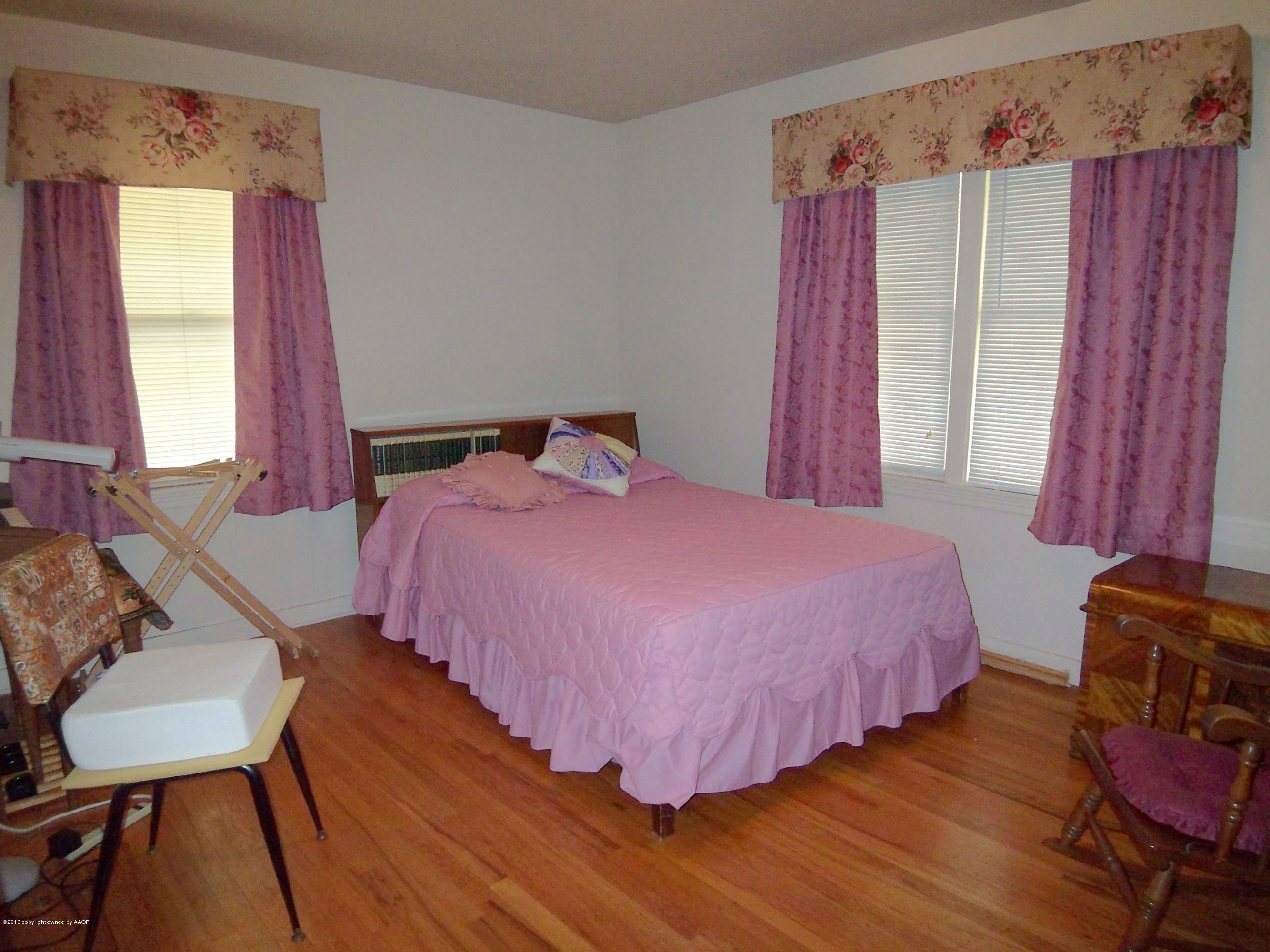 4301 Cline Road Amarillo, TX 79110 - Photo 8 of 12 a bedroom with a bed a chair and a window