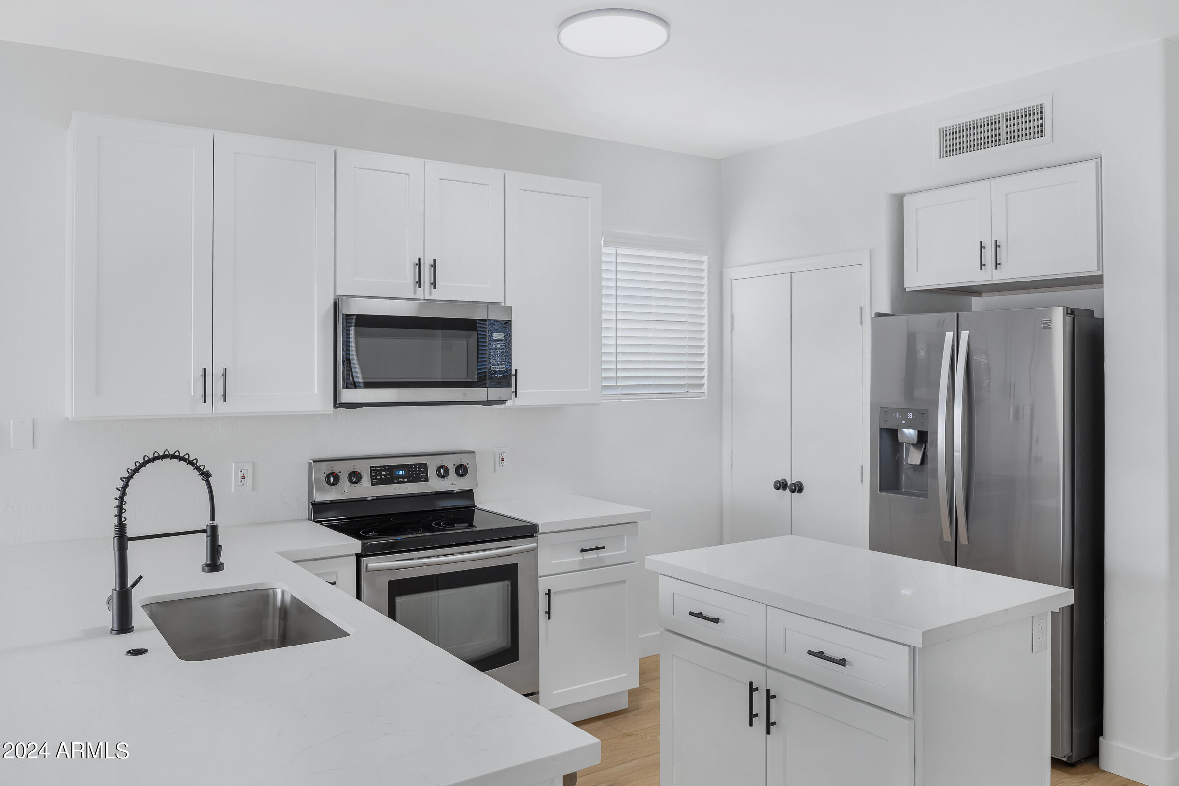 3910 West Carter Road Phoenix, AZ 85041 - Photo 14 of 40 a kitchen with a sink a stove and refrigerator