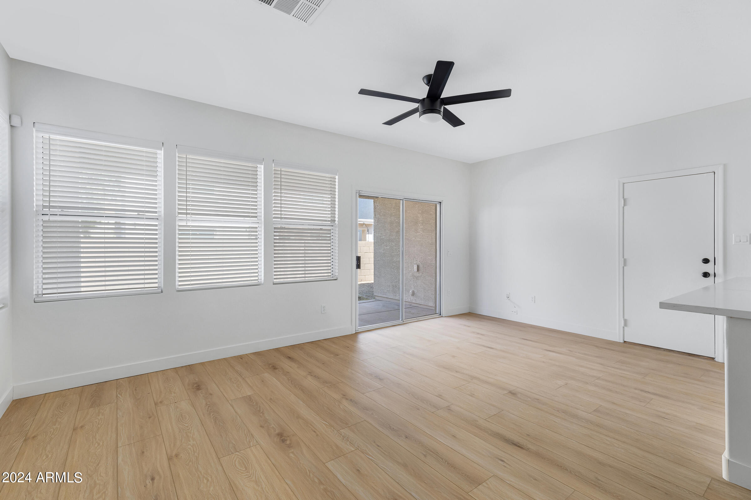 3910 West Carter Road Phoenix, AZ 85041 - Photo 18 of 40 a view of empty room with wooden floor and fan