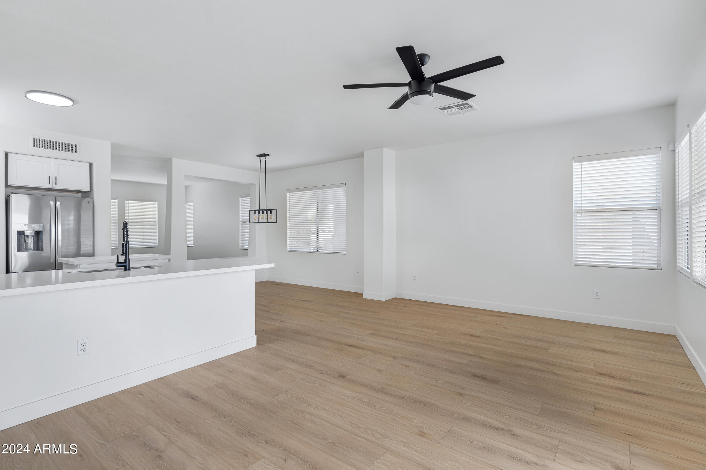 3910 West Carter Road Phoenix, AZ 85041 - Photo 19 of 40 a view of a kitchen with wooden floor and a ceiling fan