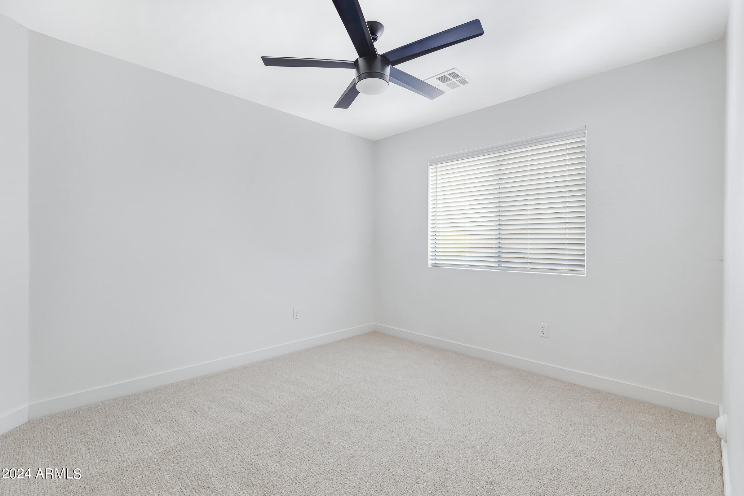 3910 West Carter Road Phoenix, AZ 85041 - Photo 26 of 40 an empty room with a window and a fan