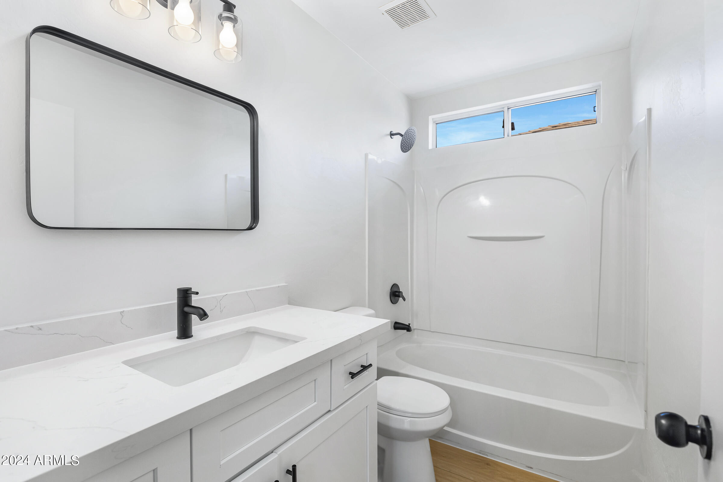 3910 West Carter Road Phoenix, AZ 85041 - Photo 29 of 40 a bathroom with a toilet sink and mirror