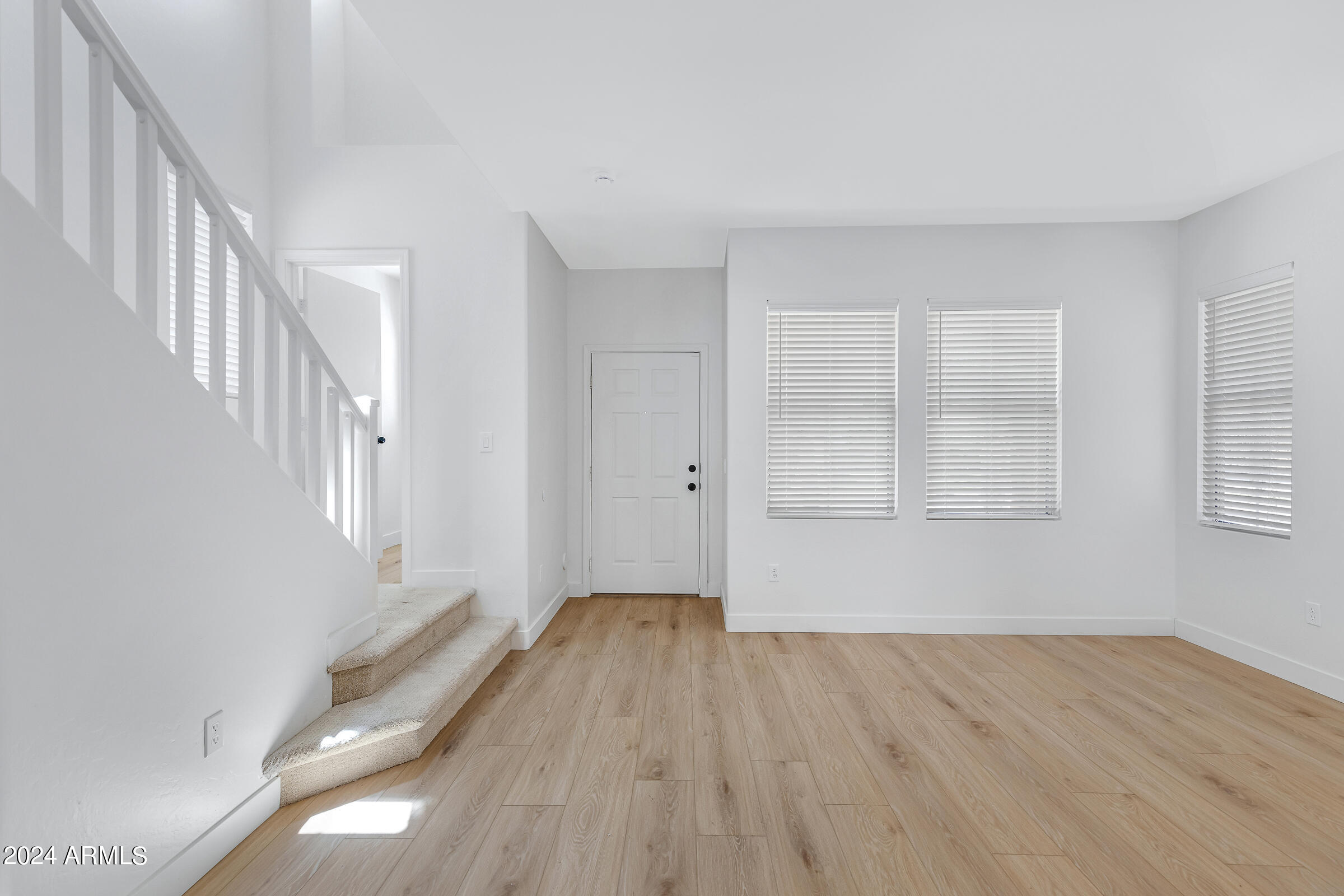 3910 West Carter Road Phoenix, AZ 85041 - Photo 6 of 40 a view of an empty room with wooden floor and a window