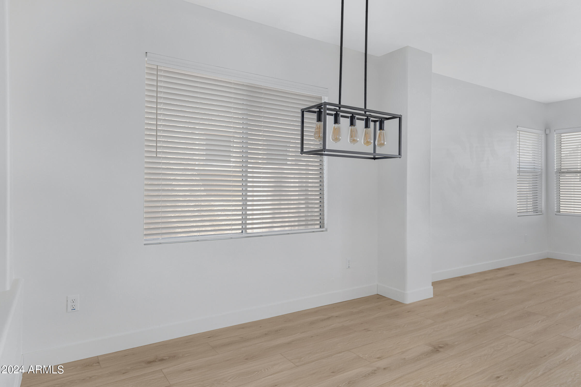 3910 West Carter Road Phoenix, AZ 85041 - Photo 10 of 40 a view of an empty room with wooden floor and a window