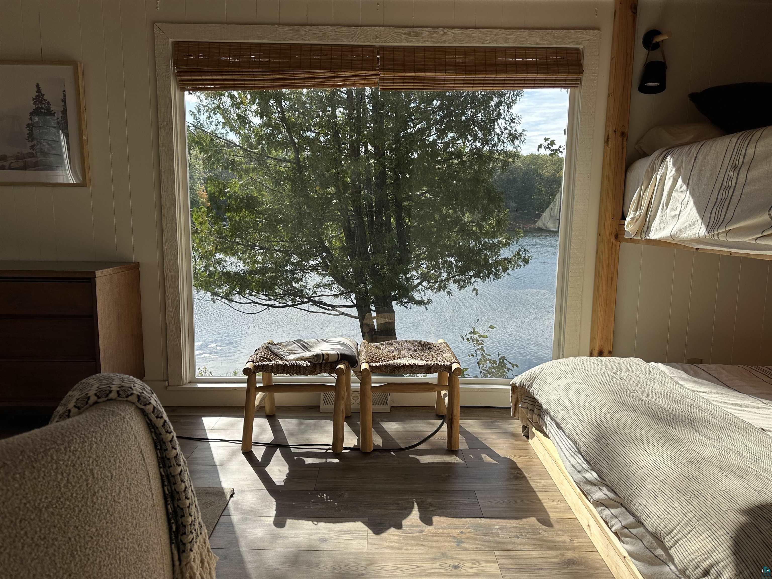 10575 Cedar Crest Road Iron River, WI 54847 - Photo 17 of 33 Bedroom with light wood-type flooring, a water view, and wooden walls