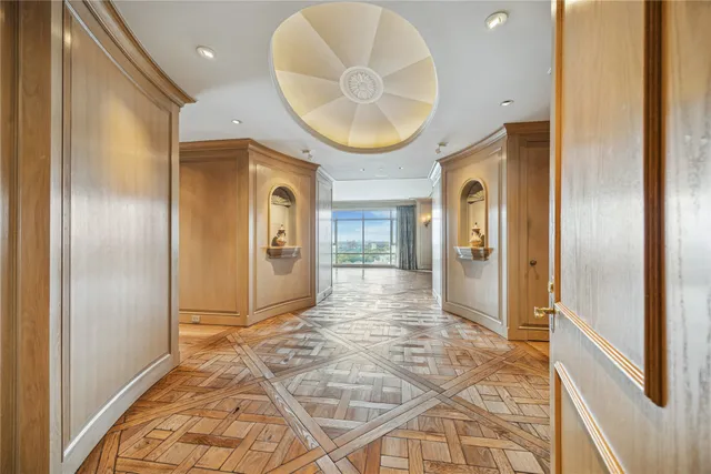a view of a hallway with wooden floor and a mirror