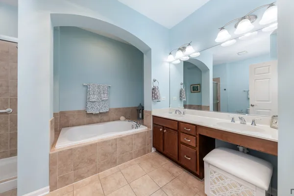 a bathroom with a tub a double vanity sink and a mirror