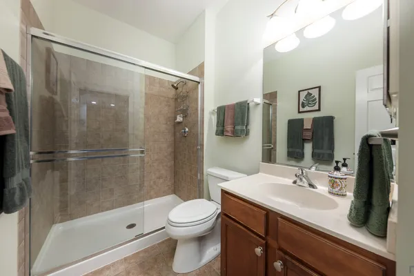 a bathroom with a sink a toilet and shower