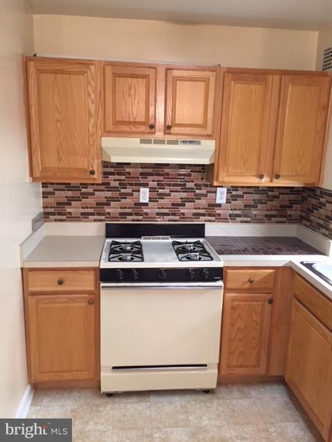 130 Slade Avenue, Unit 302 Baltimore, MD 21208 - Photo 2 of 5 a kitchen with wooden cabinets and a stove top oven