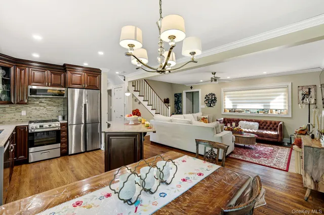 a living room with stainless steel appliances furniture or kitchen view and a dining table