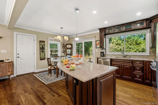 a kitchen with a stove a refrigerator a sink dishwasher with a dining table and chairs with wooden floor