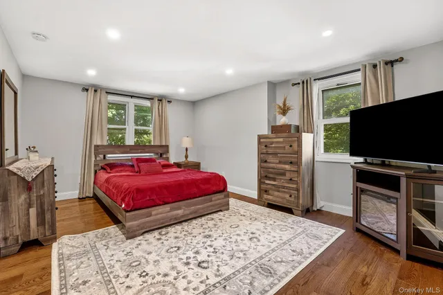 a living room with a flat screen tv and dresser