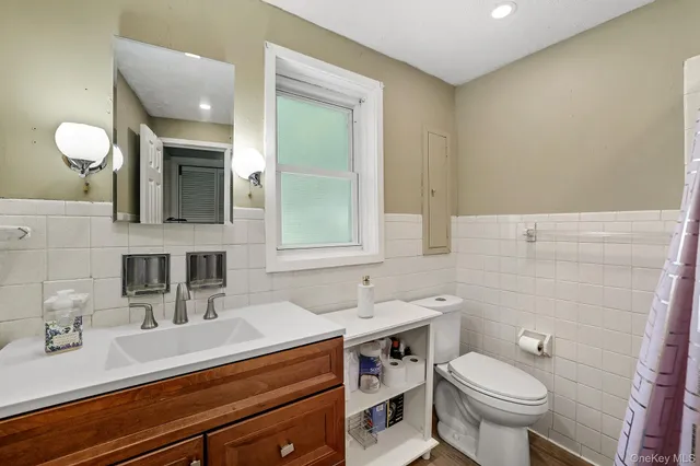 a bathroom with a toilet sink and mirror