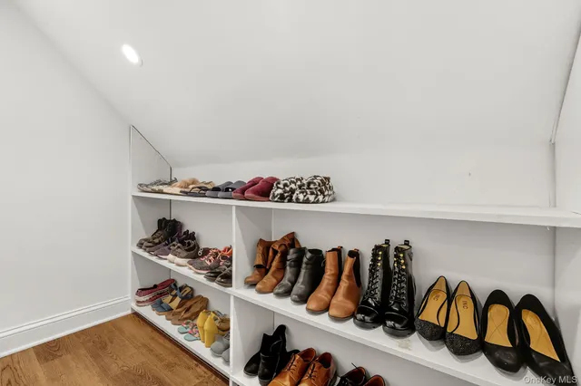 a view of walk in closet with clothes and shoes
