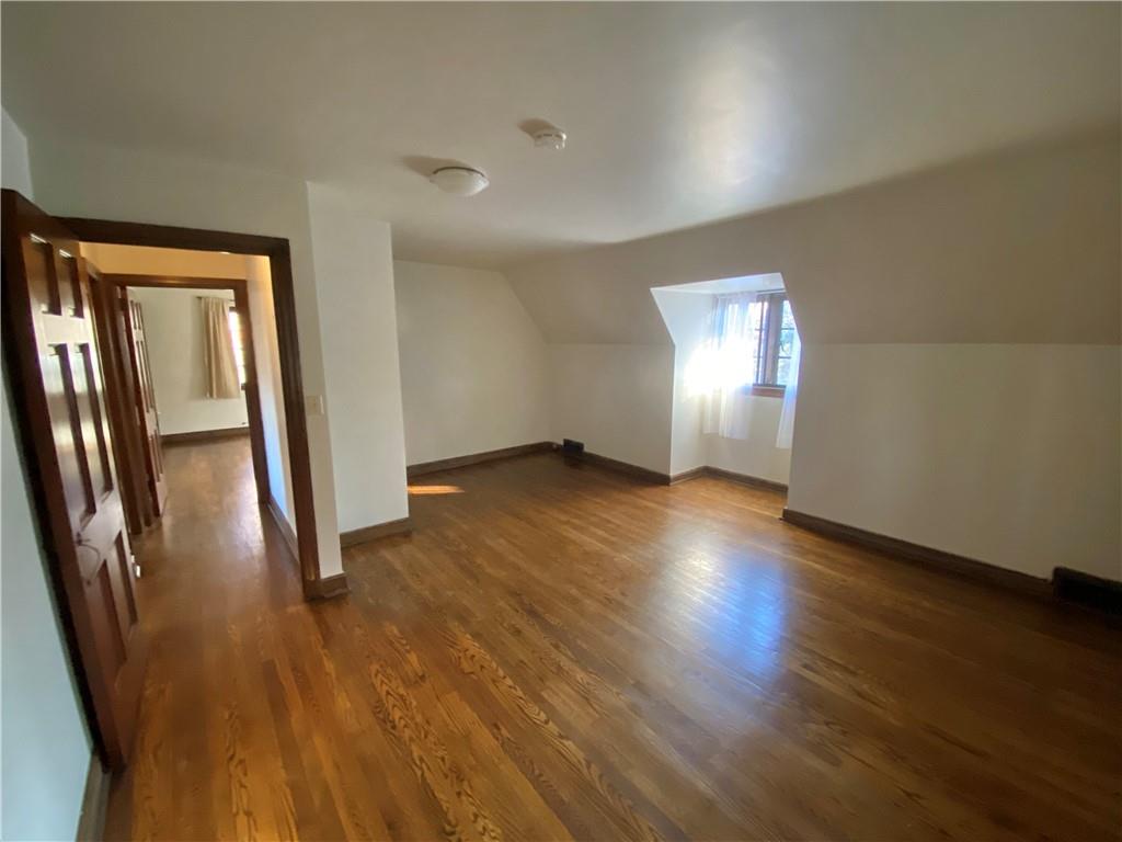 5659 Darlington Road Pittsburgh, PA 15217 - Photo 13 of 25 an empty room with wooden floor and door