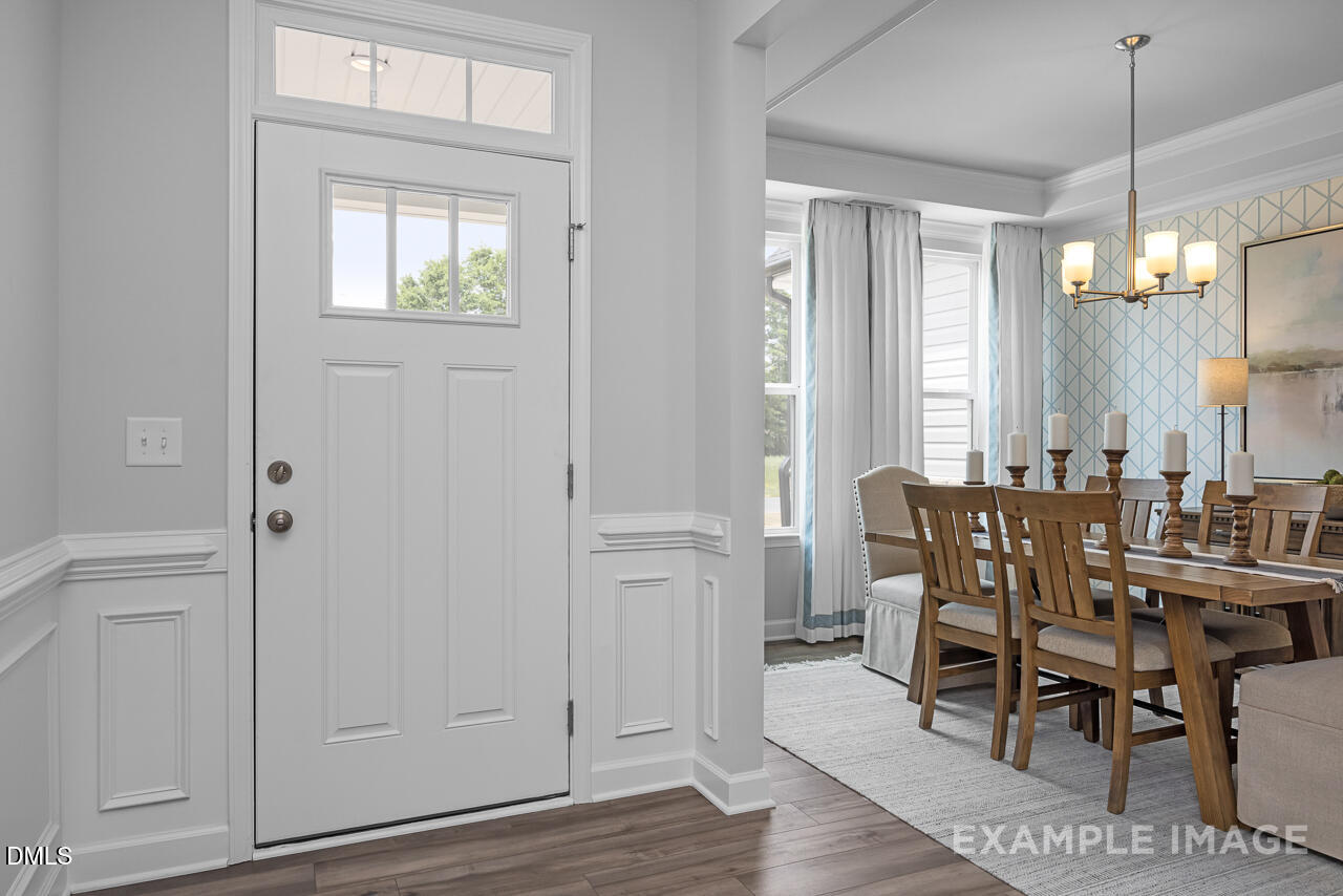 a view of a a dining room with furniture window and wooden floor