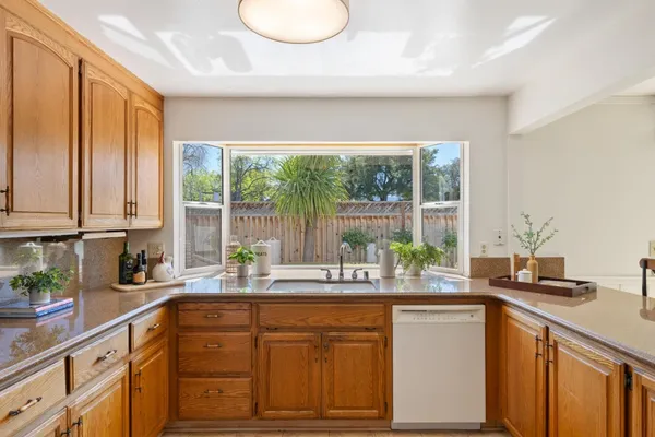 a kitchen with stainless steel appliances a sink and a large window