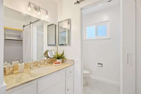 a bathroom with a granite countertop sink toilet and shower