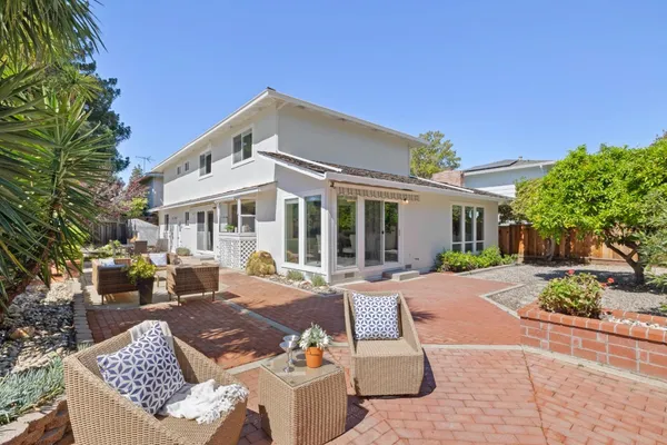 a view of a house with backyard sitting area and garden